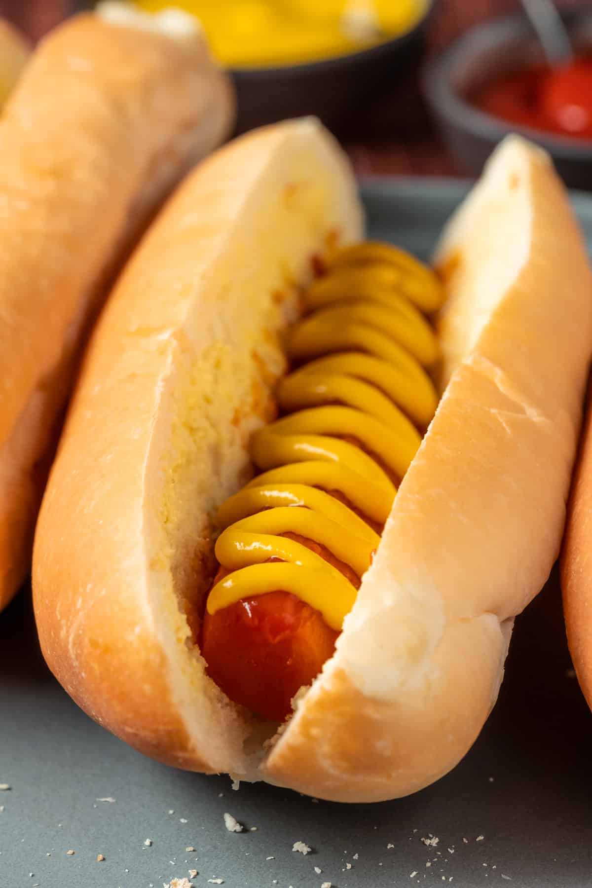 Carrot dogs with mustard on a gray plate.