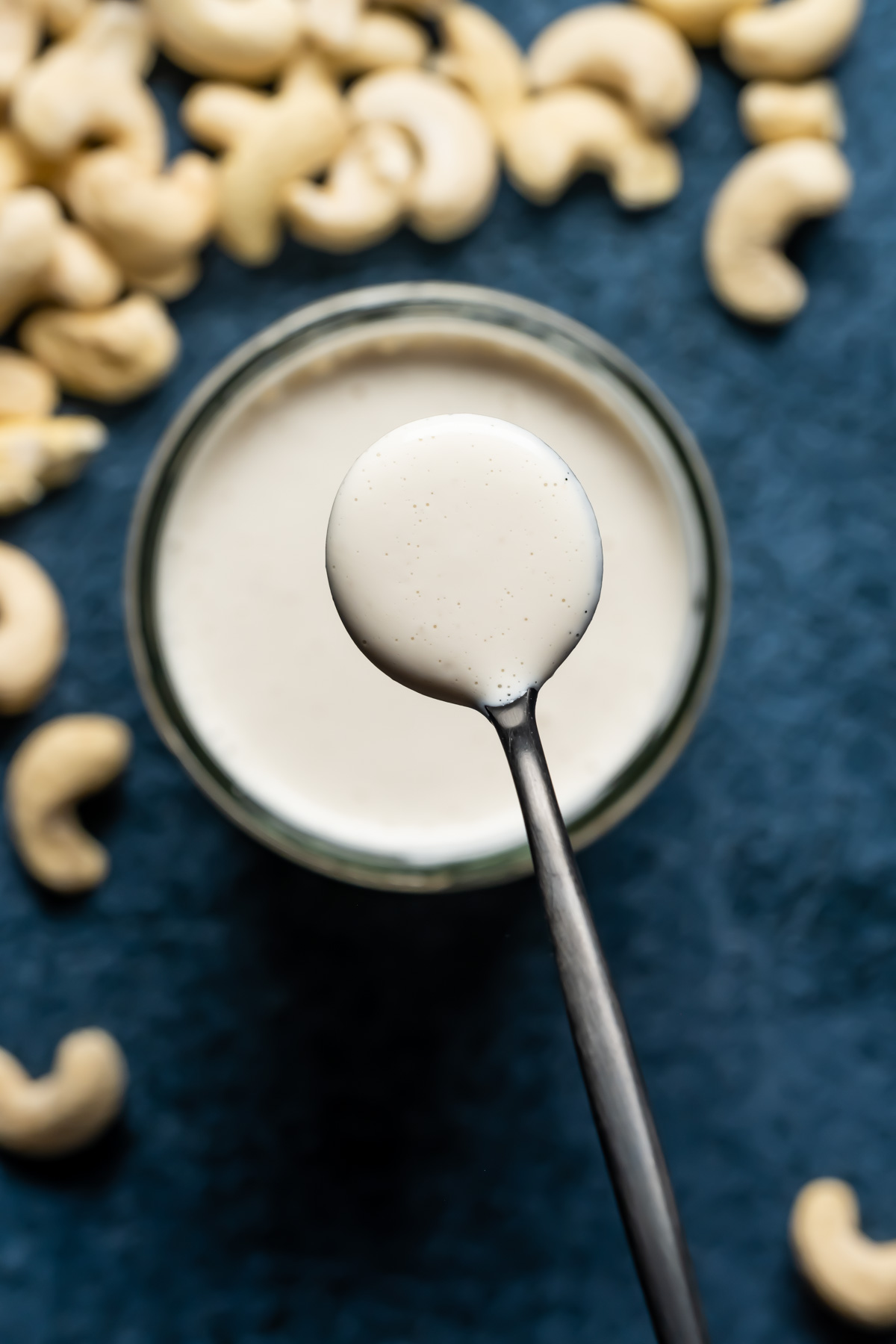 Vegan heavy cream substitute in a glass jar with a spoon.