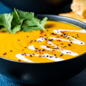 Thai sweet potato soup in a black bowl.