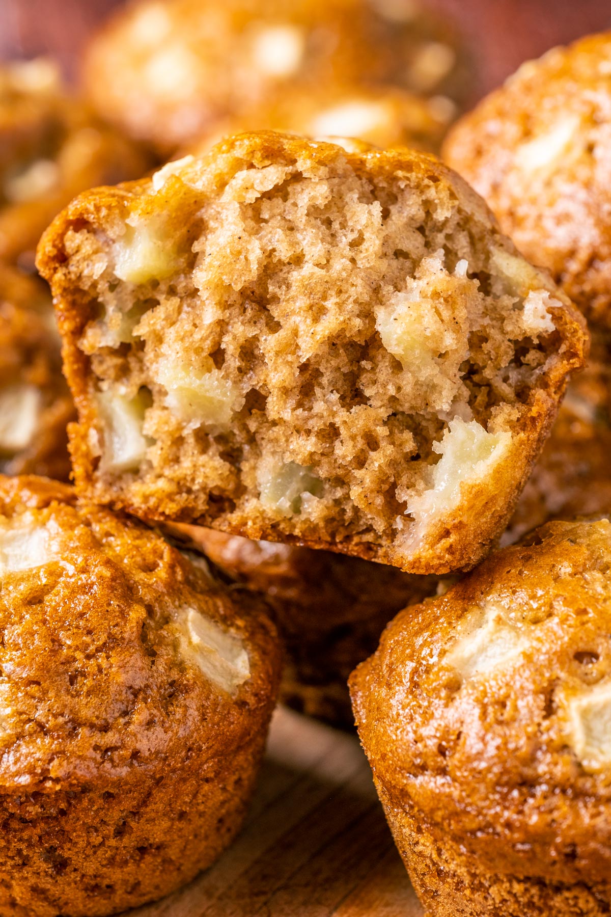 StStack of vegan apple muffins with the top muffin broken in half.