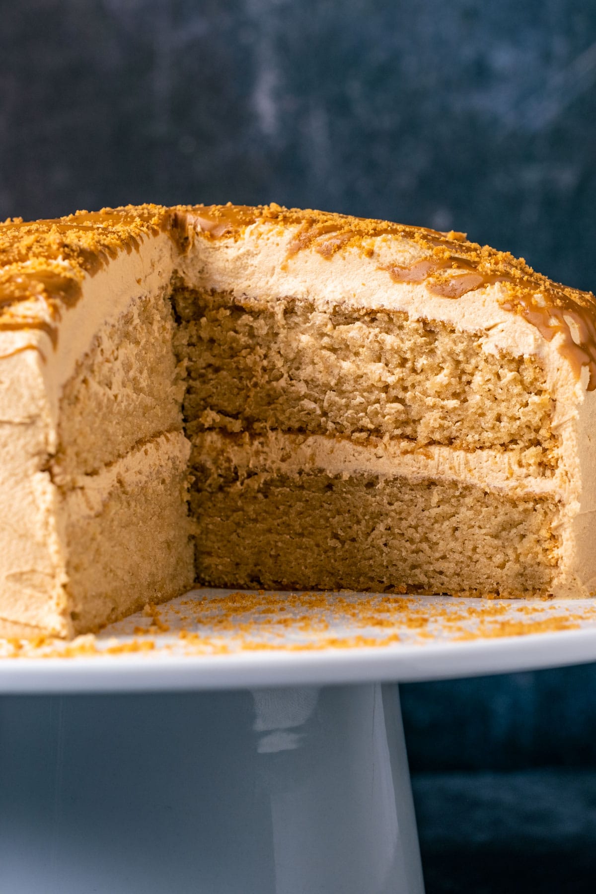 Sliced vegan biscoff cake on a white cake stand.