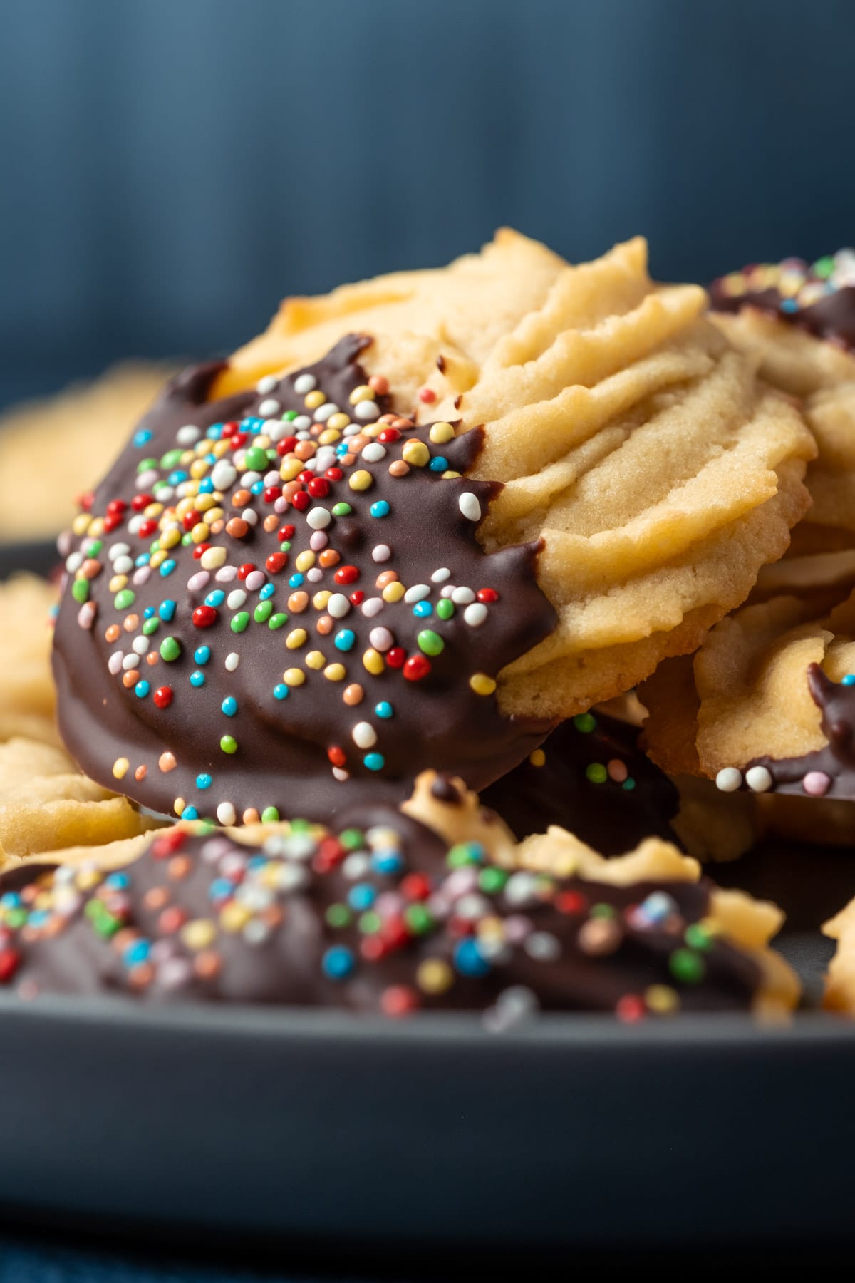 Vegan butter cookies stacked up on a plate.