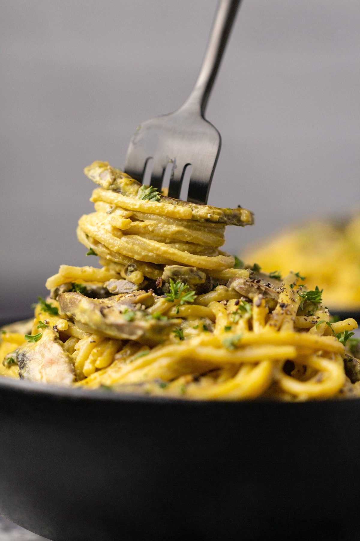 A fork twisting into a bowl of vegan carbonara. 