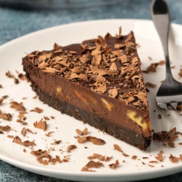 Slice of vegan chocolate tart on a white plate with a cake fork.