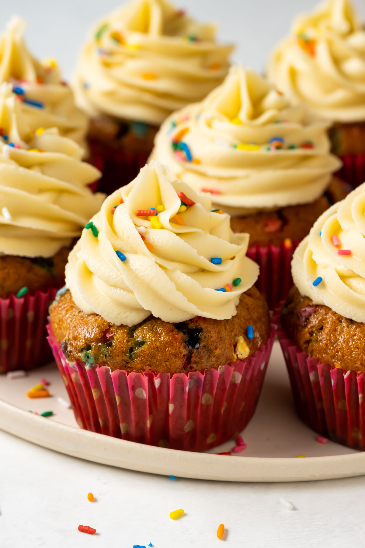 Vegan funfetti cupcakes on a white plate. 