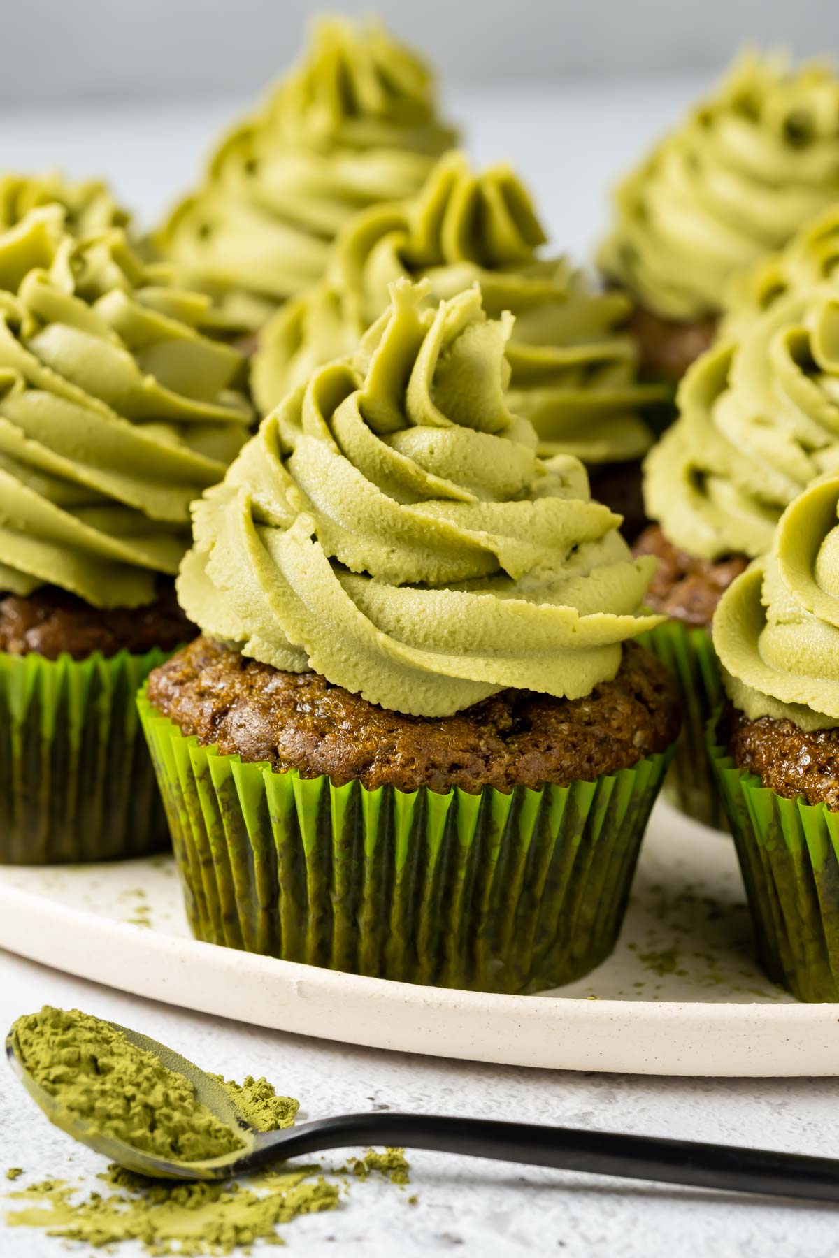 Vegan matcha cupcakes on a white plate.