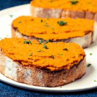 Slices of toast spread with vegan pâté on a white plate.