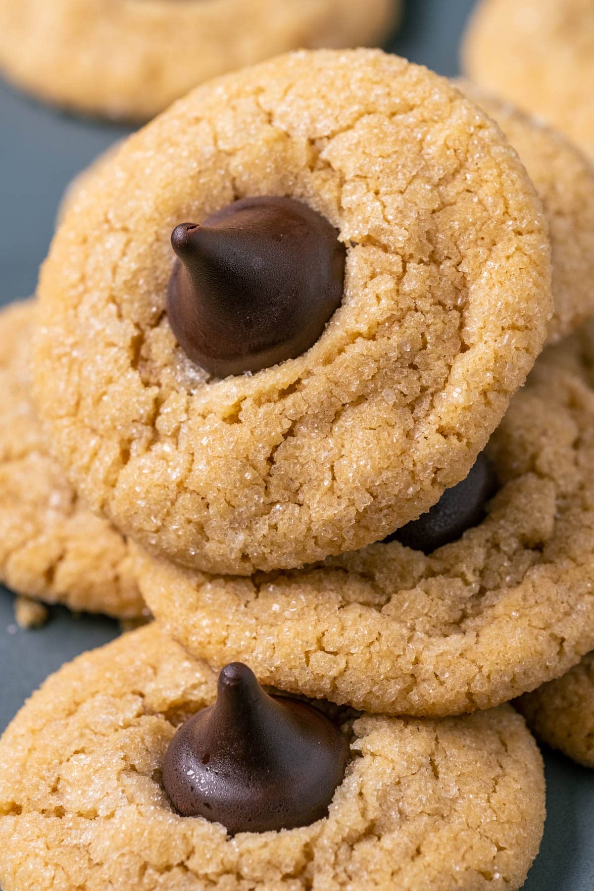 Vegan peanut butter blossoms stacked up on a gray plate.