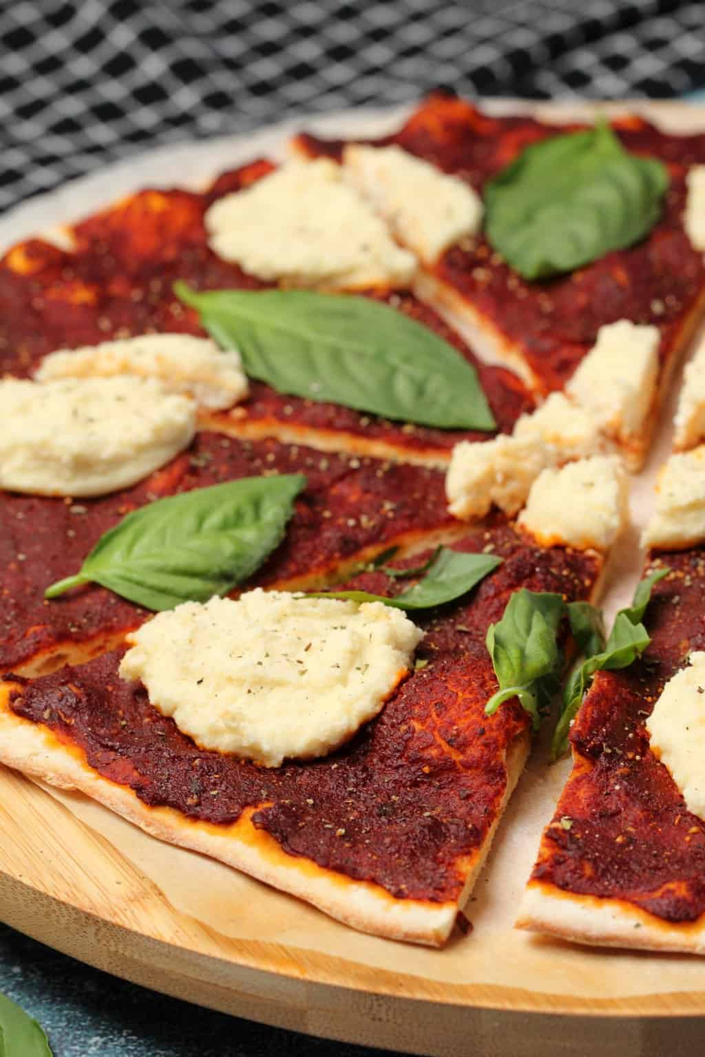 Vegan pizza topped with fresh basil and vegan ricotta. 