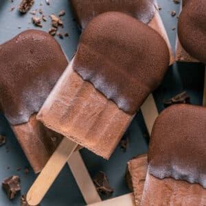 Chocolate popsicles stacked up on a plate.