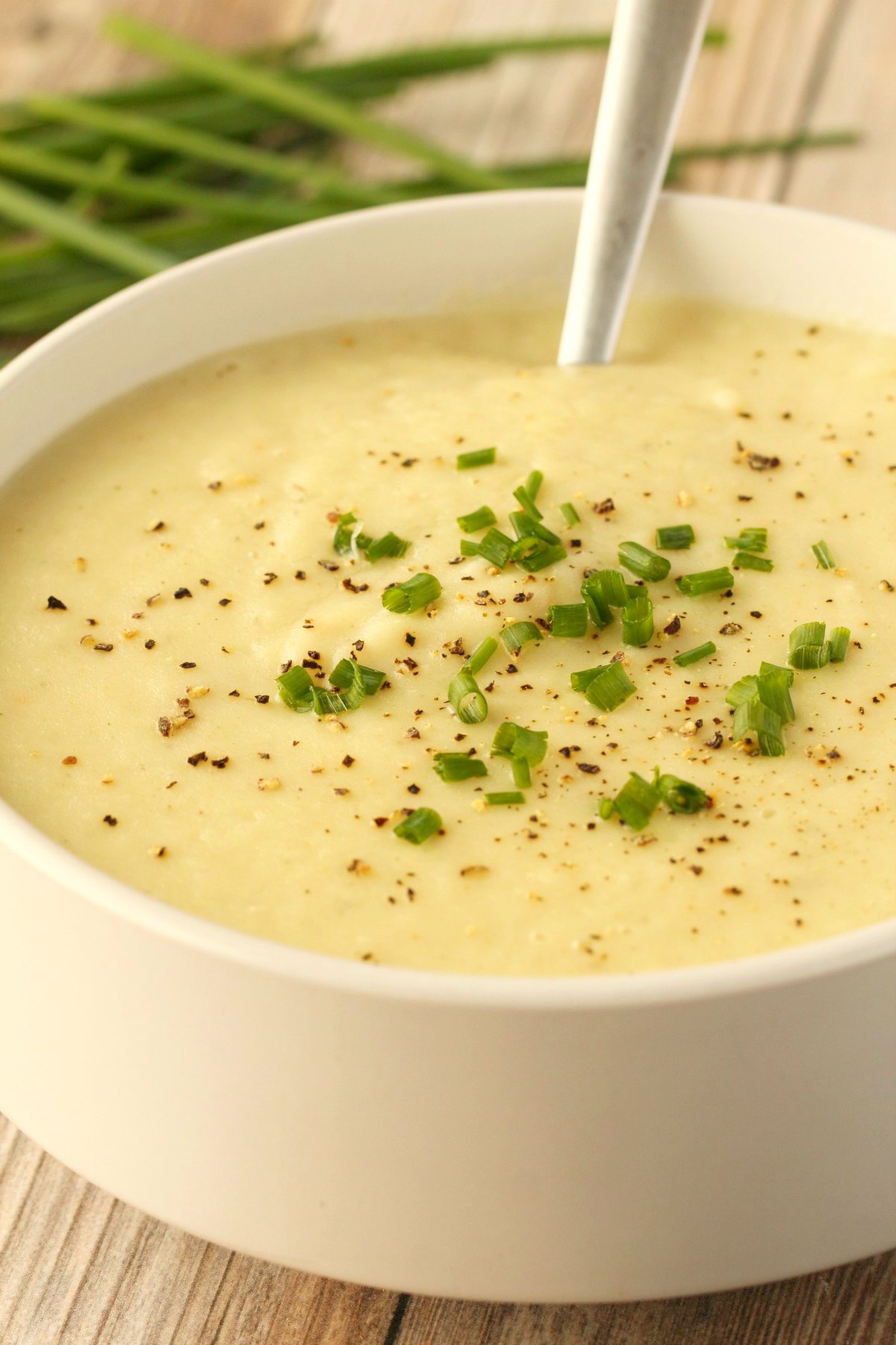 Vegan potato leek soup in a white bowl with a spoon. 