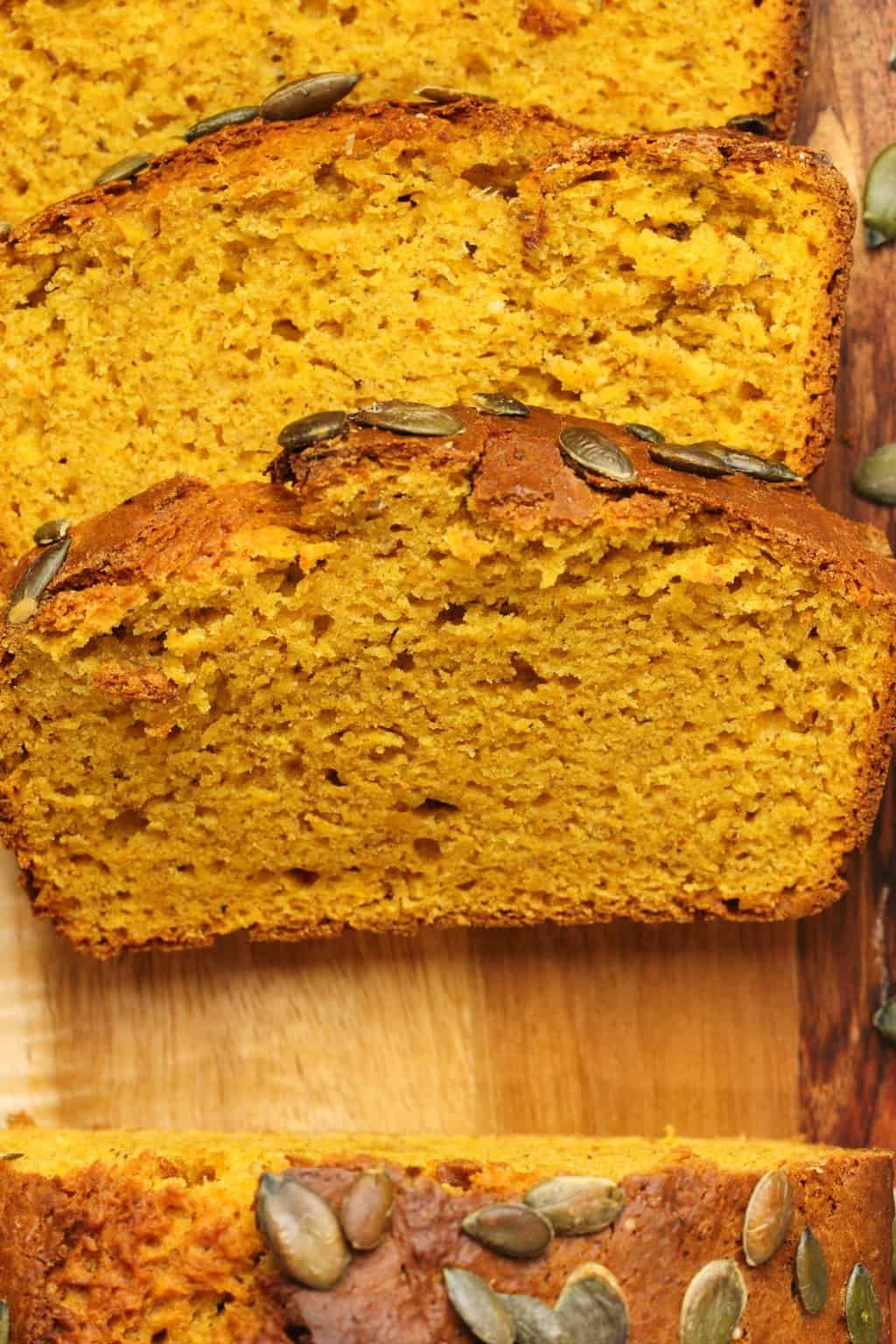 Slices of vegan pumpkin bread on a wooden board. 