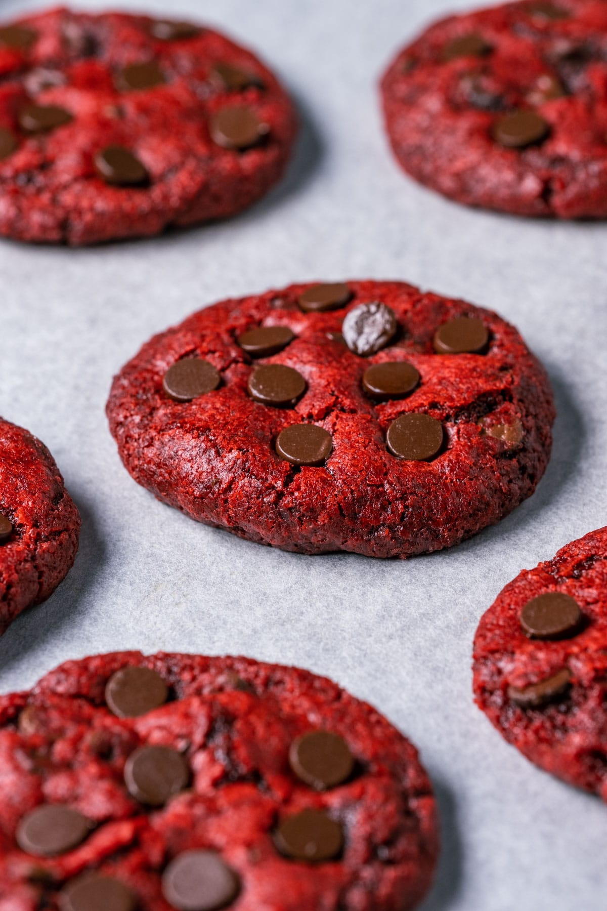 Vegan red velvet cookies on a parchment lined baking sheet.