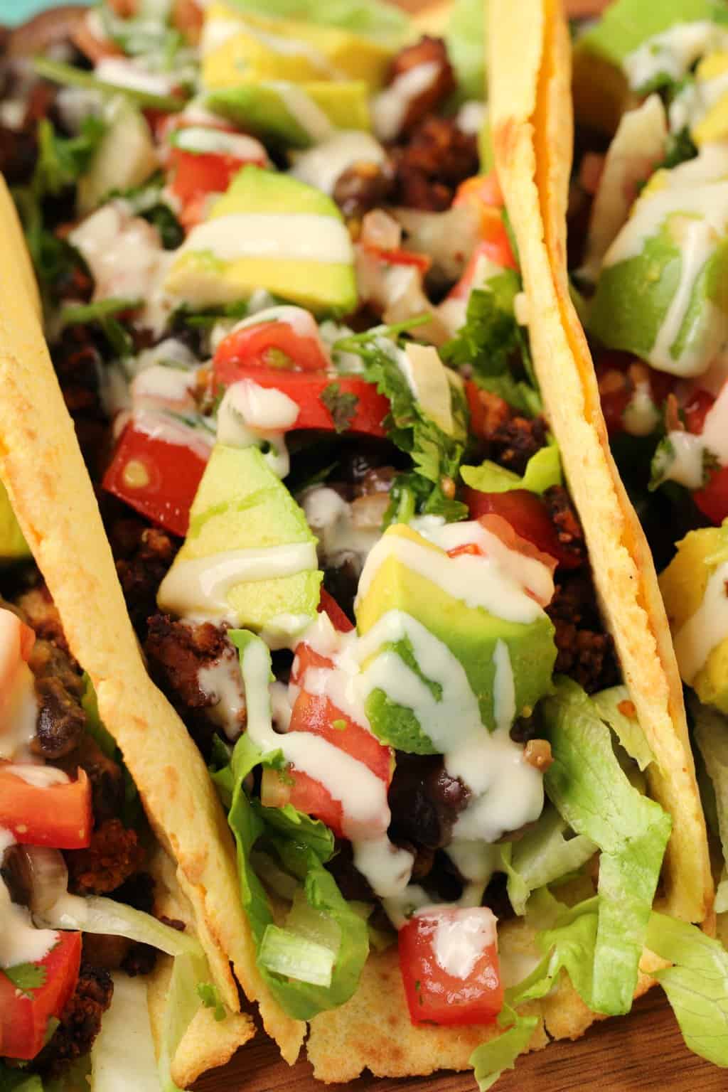 Stuffed vegan tacos on a wooden board. 