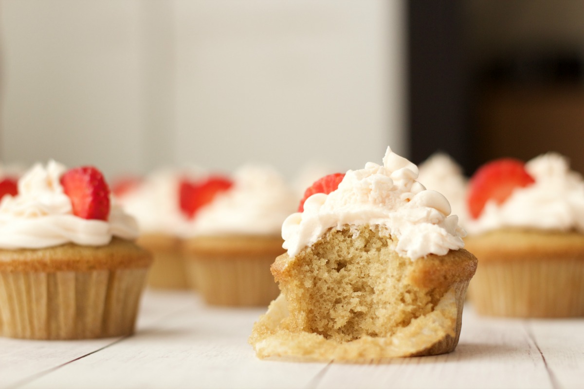 Vegan vanilla cupcake with a bite out of it. 